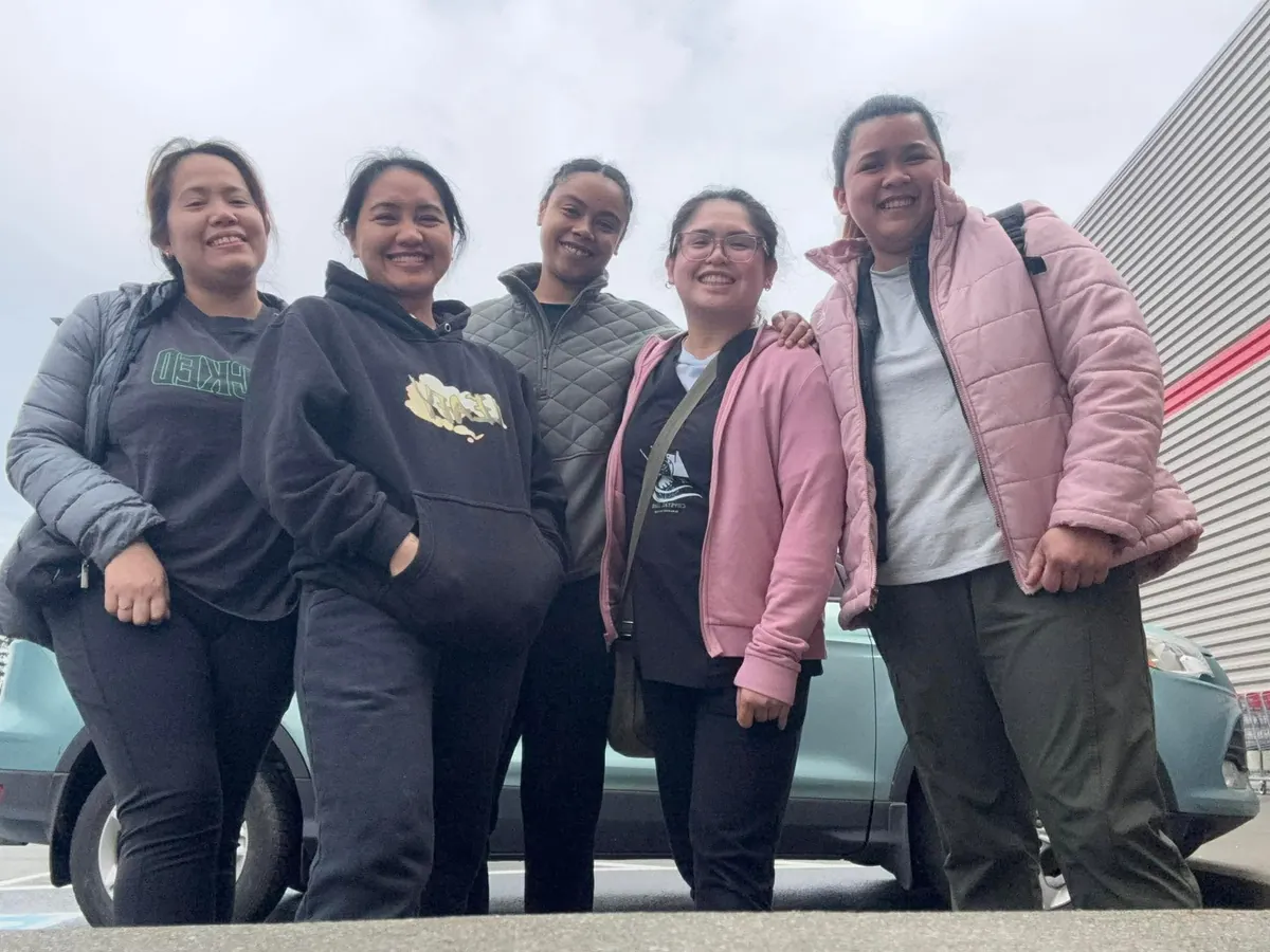 Five Crystal Care team members in winter jackets smiling together on a day out